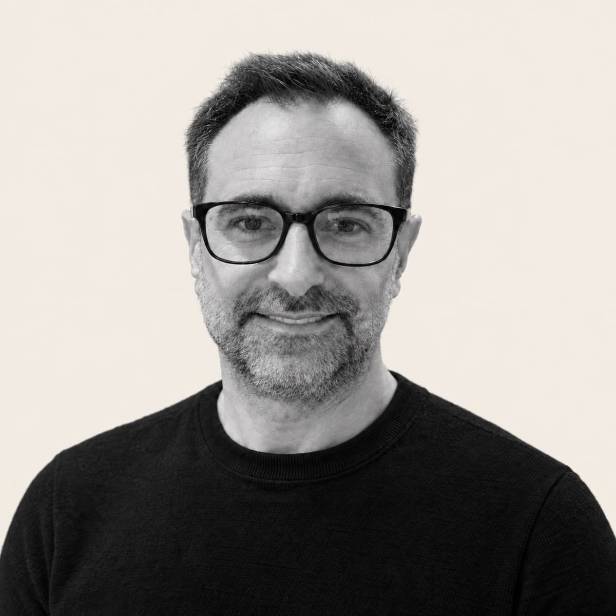 Portrait de Jean-Philippe Poisson, souriant, en noir et blanc sur fond crème.