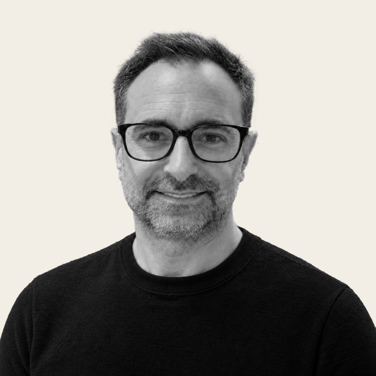 Portrait de Jean-Philippe Poisson, souriant, en noir et blanc sur fond crème.